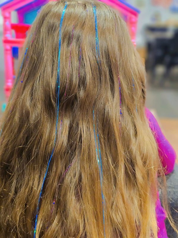 Blonde hair threaded with blue and teal tinsel